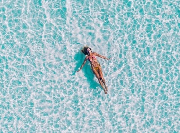 Woman floating on sunny blue Hawaiian water