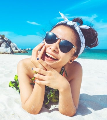 smiling woman lounging on a sunny beach