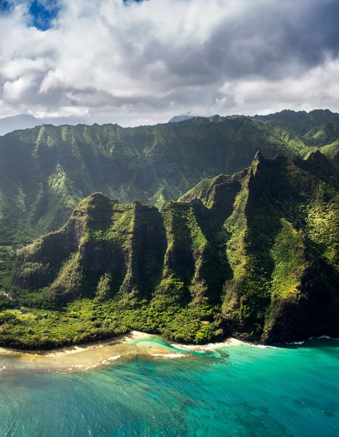 Jungle mountains behind a sunny Hawaiian beach